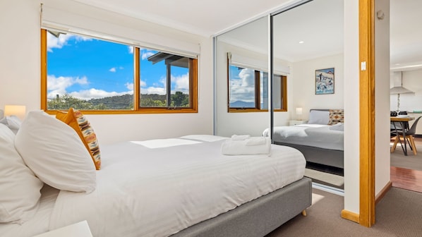 Enjoy a scenic mountain view from the comfort of this stylish room, featuring a large bed and a spacious workspace.