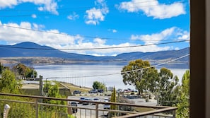 Enjoy serene views of the lake and distant mountains from this lakeside retreat's balcony.