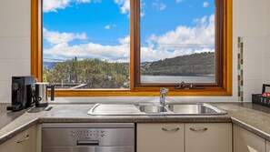 Enjoy a scenic view from the kitchen window, where you can make a fresh cup of coffee and wash dishes in the double sink.