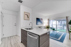 A modern kitchen with a dishwasher, a sink, and a large window.