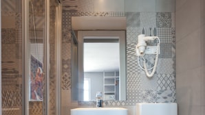 A modern bathroom with a glass shower enclosure, a white sink, and a toilet. - Ryans Budget (Ibiza Town)