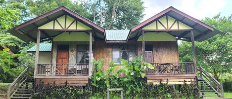 A two-story lodge with a wooden exterior, a covered porch, and a staircase leading to the upper level.