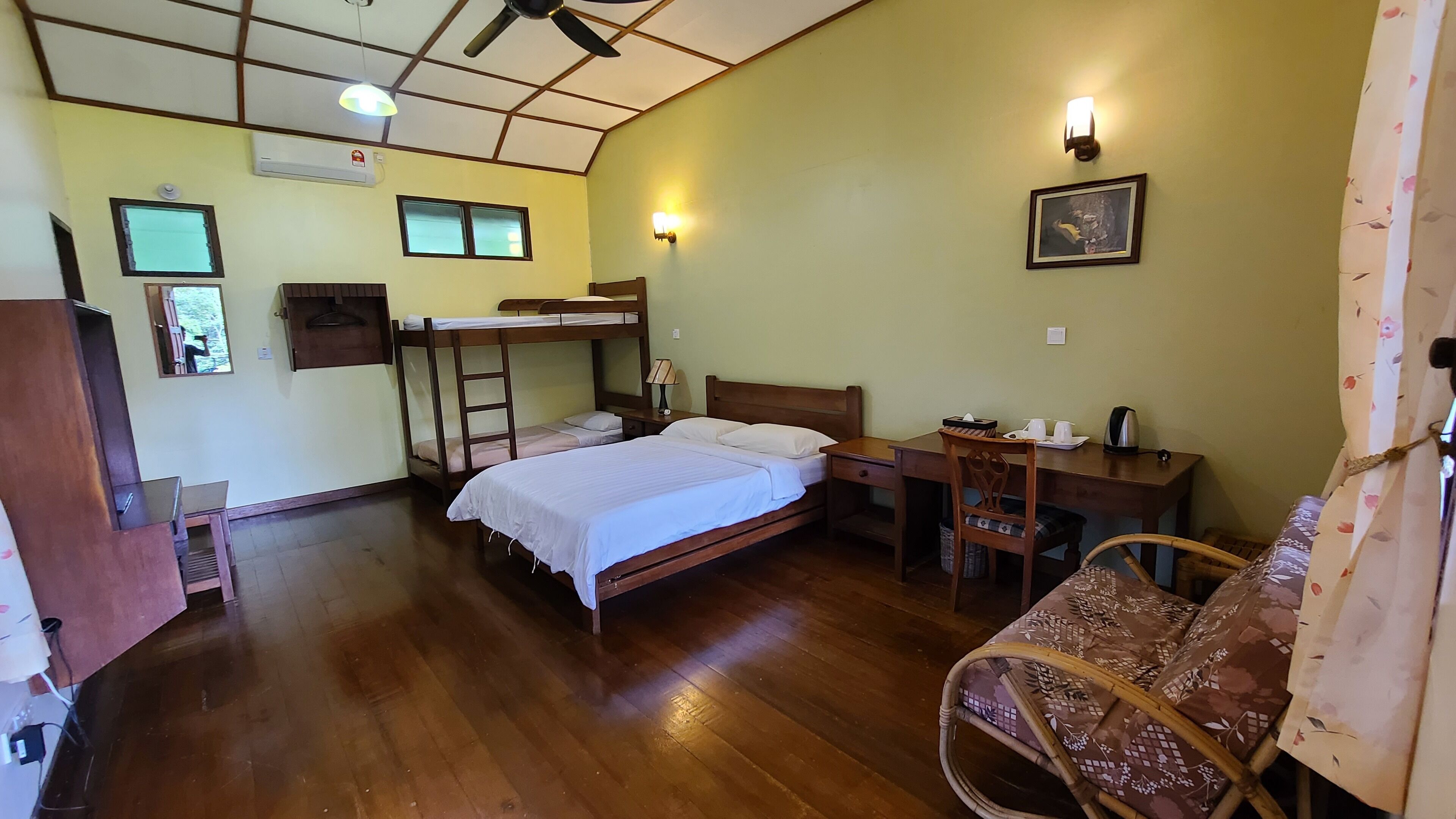 A room with bunk beds, a desk, a chair, and a bed.
