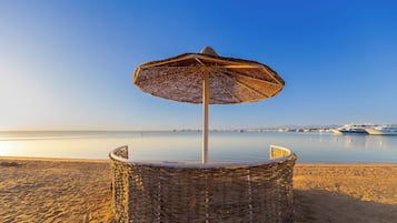 Playa privada, arena blanca, sillas reclinables de playa, sombrillas