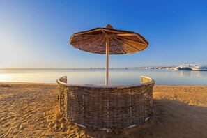 Privat strand, vit sandstrand, solstolar och parasoller