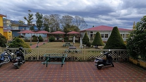 A courtyard with a paved area, benches, and a gazebo. - Madpackers Bir  (Baijnath)