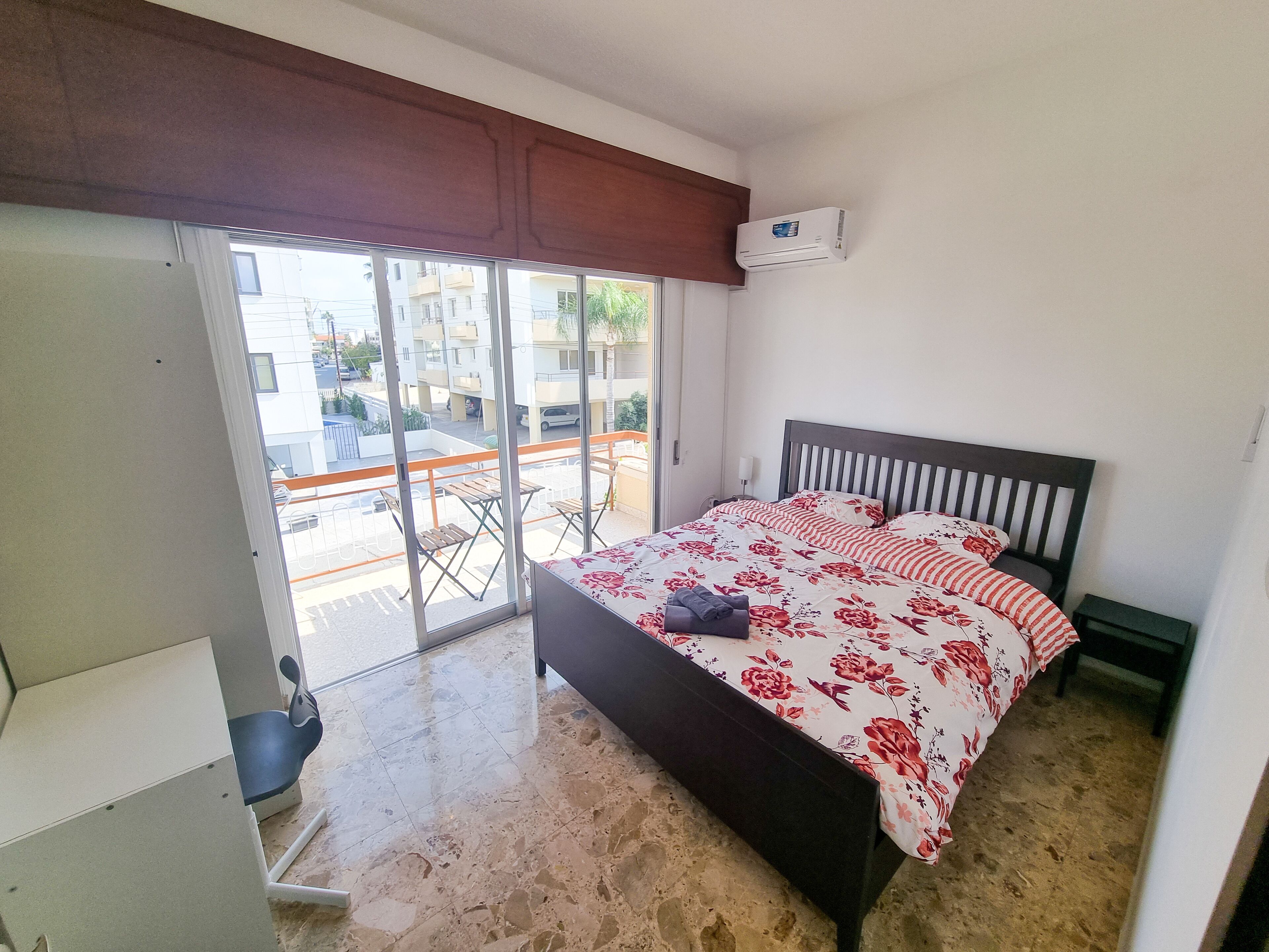Une chambre à coucher avec un lit, une fenêtre, une porte coulissante et une vue sur l’extérieur.