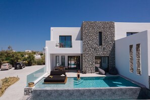 A modern house with a swimming pool, stone facade, and a clear view of the surrounding landscape. - Milestones Naxos Hotel (Naxos)