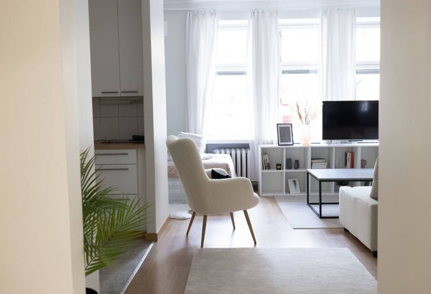 Ein modernes Wohnzimmer mit einer Couch, einem Fernseher und einem Bücherregal.