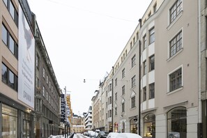 A street with buildings, a sign for 'Forum', and parked cars.