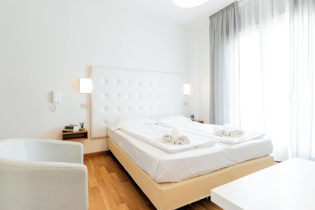Klassieke driepersoonskamer, balkon | Donzen dekbedden, een kluis op de kamer, een bureau