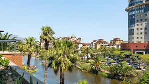 A riverside view with palm trees and a parking lot. - Knightsbridge 108 (Cape Town)