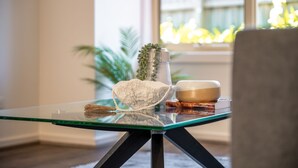 Une table en verre sur laquelle reposent un saladier en osier, un bol en céramique et un livre intitulé « A Dog’s Purpose » de W. Bruce Cameron.