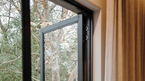 A glass door leading to an outdoor area with a metal fence and trees. - The Hawthorn Boutique Hotel (George)