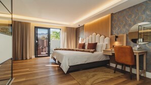A modern bedroom with a large bed, a desk, and a mirror. There is a view of the outdoors through a glass door. - The Hawthorn Boutique Hotel (George)