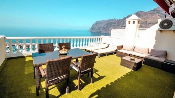 A terrace with a table and chairs, a sofa, and a view of the sea and mountains. - Apartment - LOS GIGANTES (Santiago del Teide)