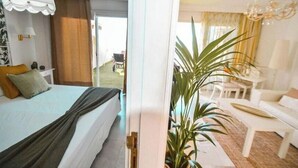 A hotel room with a bed, a desk, a chair, and a potted plant. - Apartment - LOS GIGANTES (Santiago del Teide)
