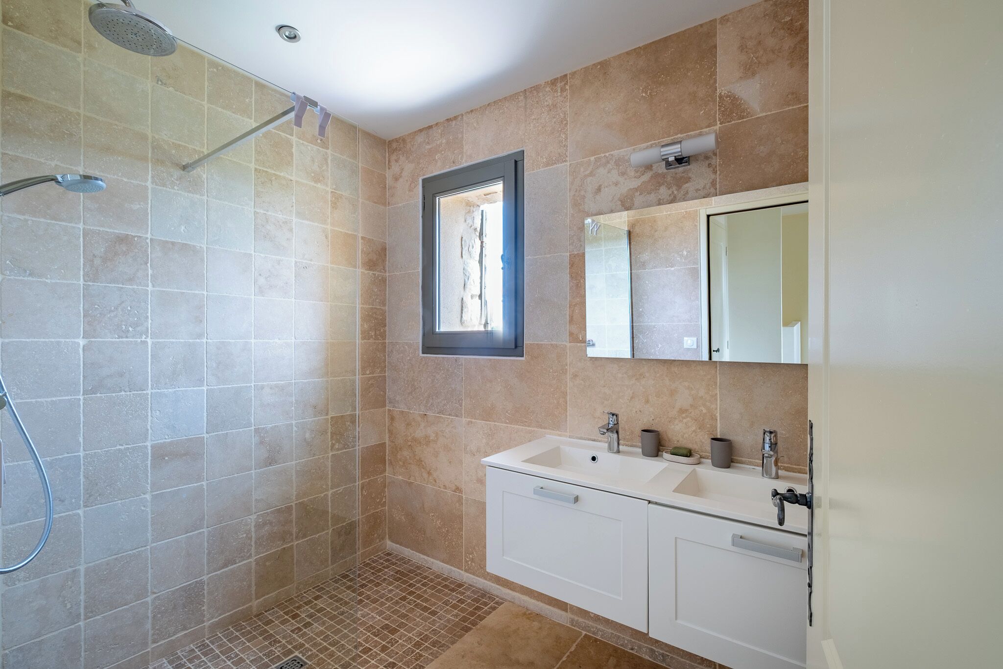 A bathroom with a shower, a sink, and a mirror.