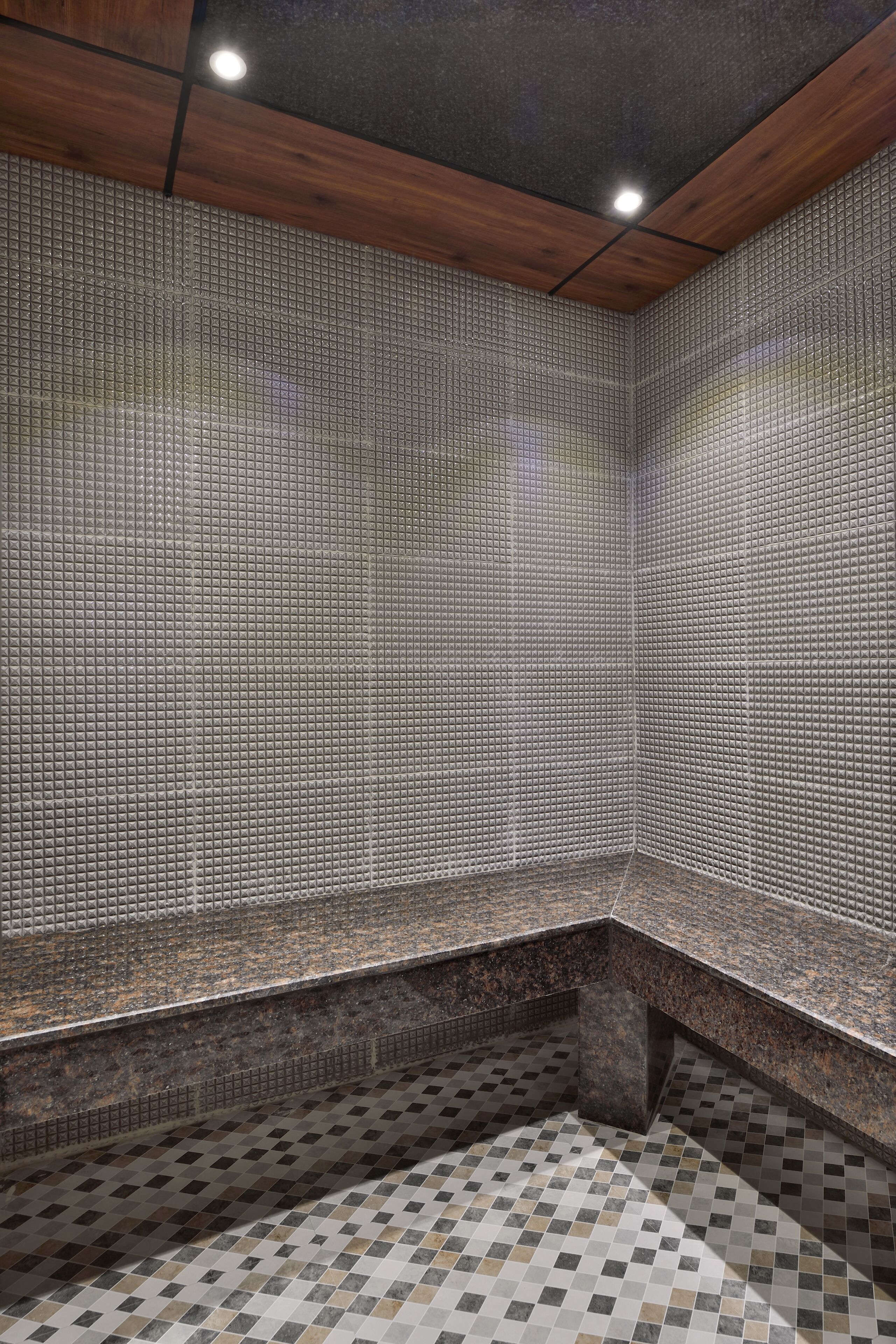 A corner of a room with a checkered floor and tiled walls.