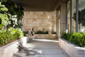 A stone facade with the word "SIGNATURE" and a pathway leading to a building entrance. - ULTIQA Signature at Broadbeach (Broadbeach)