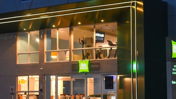 A modern building with a glass facade, a sign reading "IBIS Styles," and a visible staircase leading to an upper level. - Ibis Styles Garanhuns (Garanhuns)
