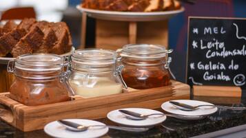 A breakfast buffet with bread, jams, and condiments.