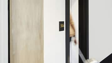A hallway with a curved wall, a door labeled "506", and a striped carpet.