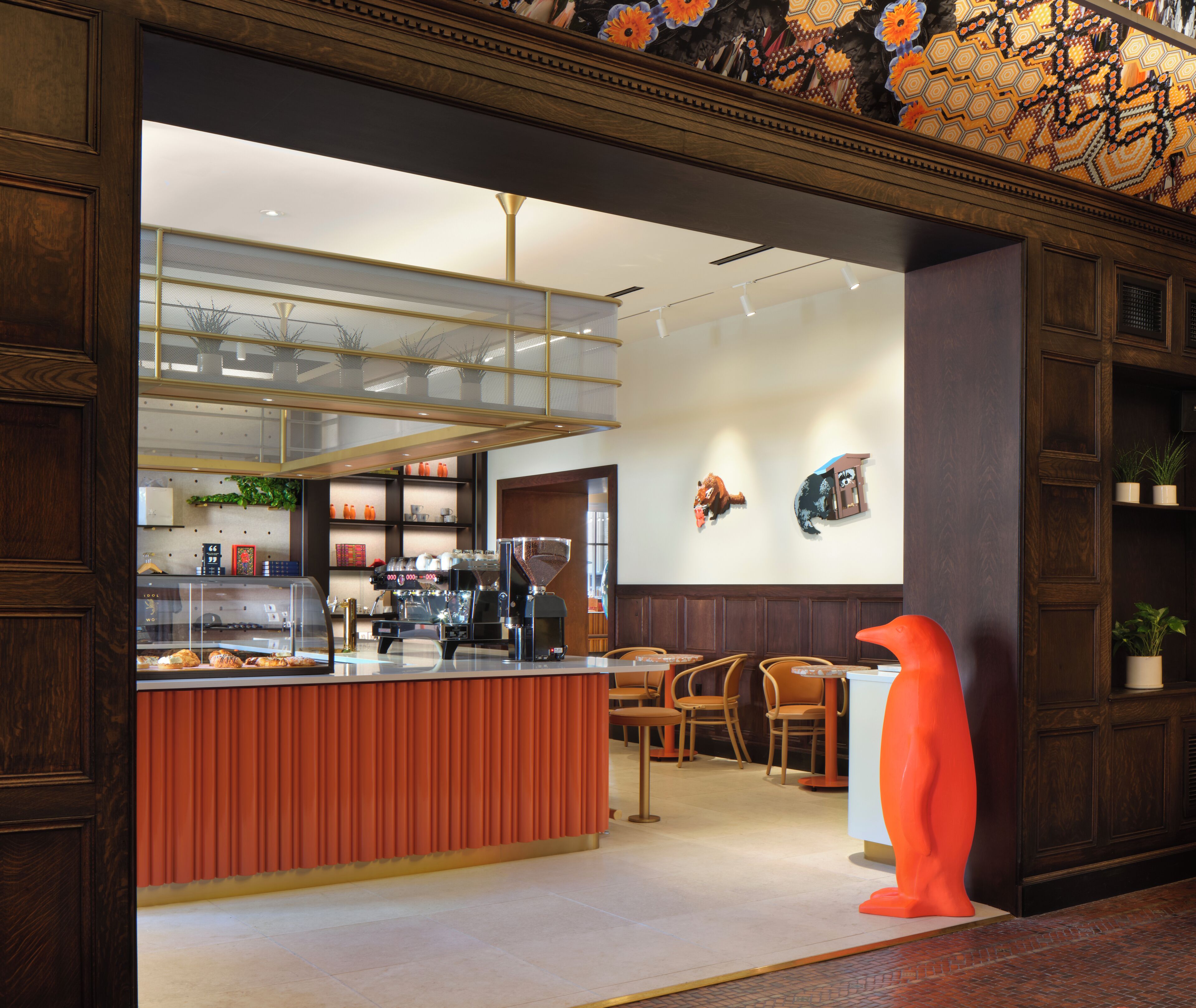 A modern interior with a wooden reception desk, seating area, and decorative wall art.