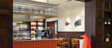 A modern interior with a wooden reception desk, seating area, and decorative wall art.