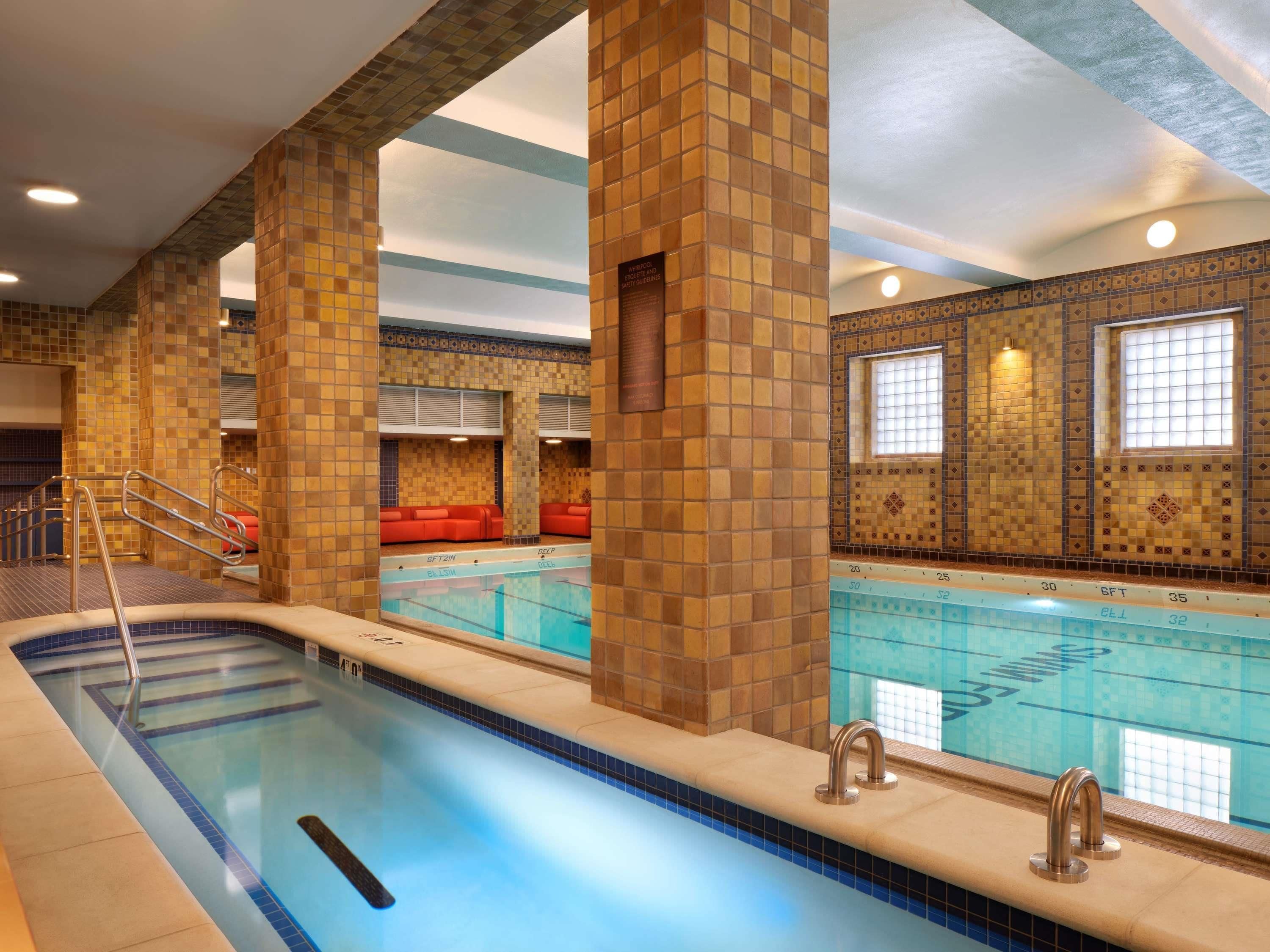 An indoor swimming pool with tiled walls and a clear pool area.