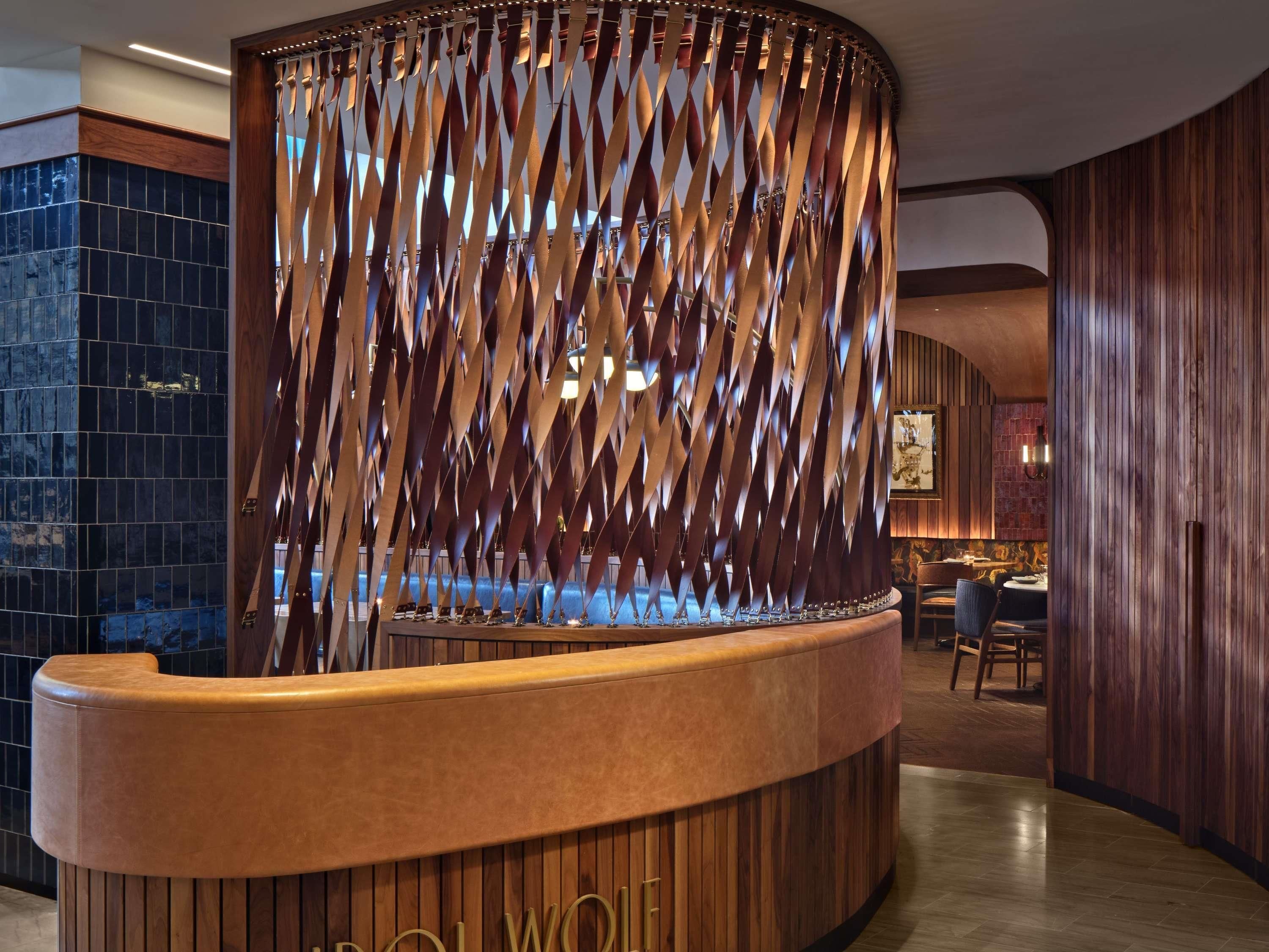 A reception desk with a curved design, a wooden panel wall, and a tiled floor.