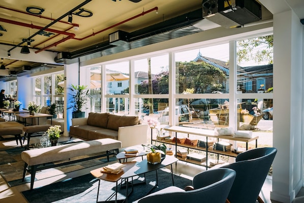 Un salón amplio y luminoso con asientos cómodos, una mesita de centro y vistas al exterior.