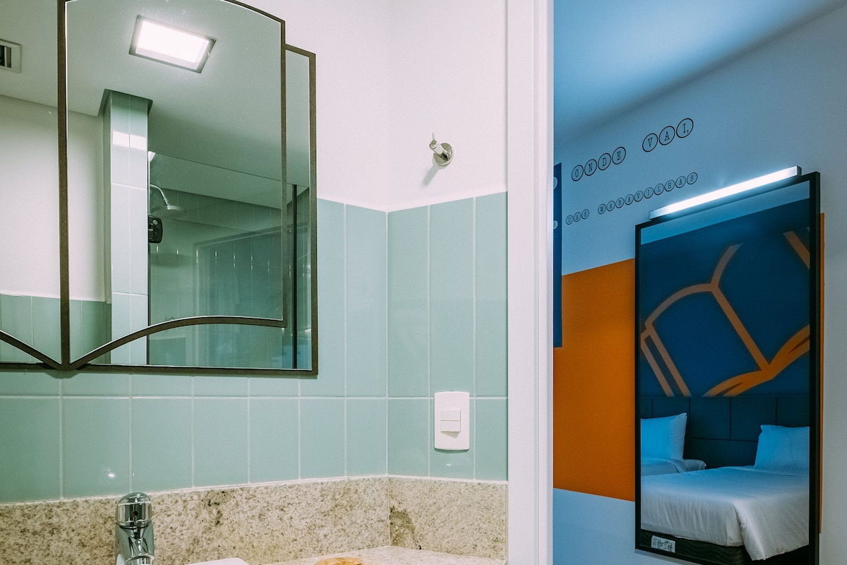 Un baño moderno con lavamanos, espejo y un cuadro enmarcado en la pared.
