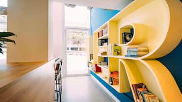 A modern library with bookshelves, a wooden table, and chairs.
