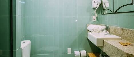 A bathroom with a toilet, sink, and mirror.