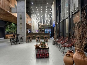 A modern interior with a bar area, seating, and decorative elements like plants and vases. - Ibis Styles Maceió Pajuçara (Maceió)