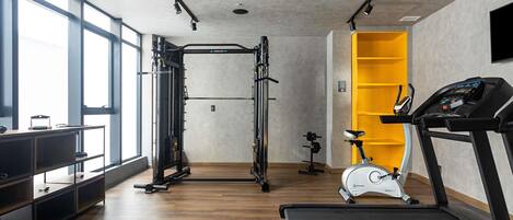 A gym with exercise equipment, a treadmill, and a stationary bike.