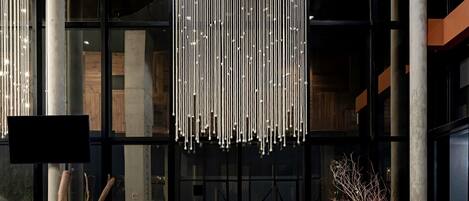 Un interior con lámparas colgantes, sillas de madera y un gran ventanal.