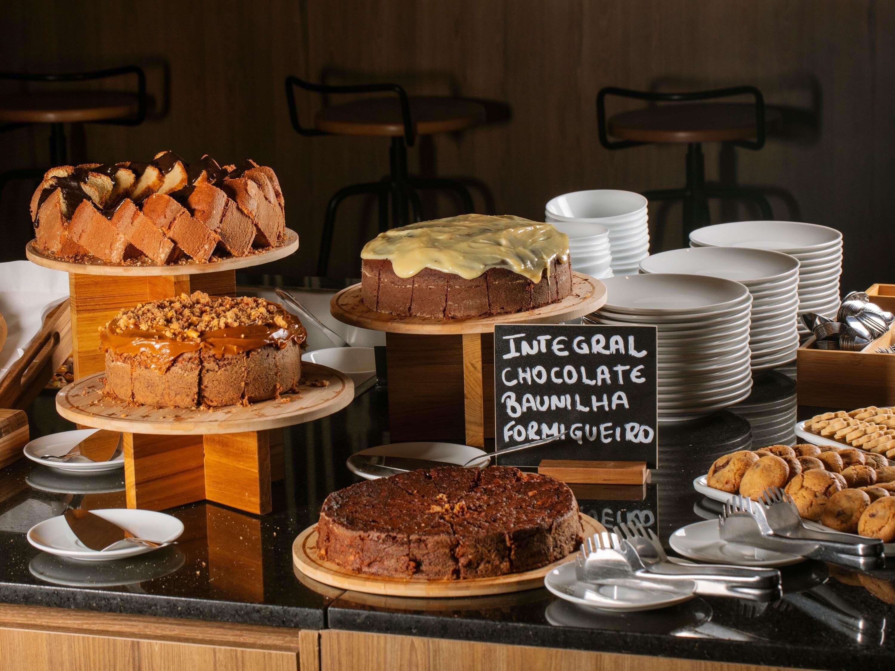 A buffet with various desserts, including cakes and cookies, and a sign indicating chocolate options.