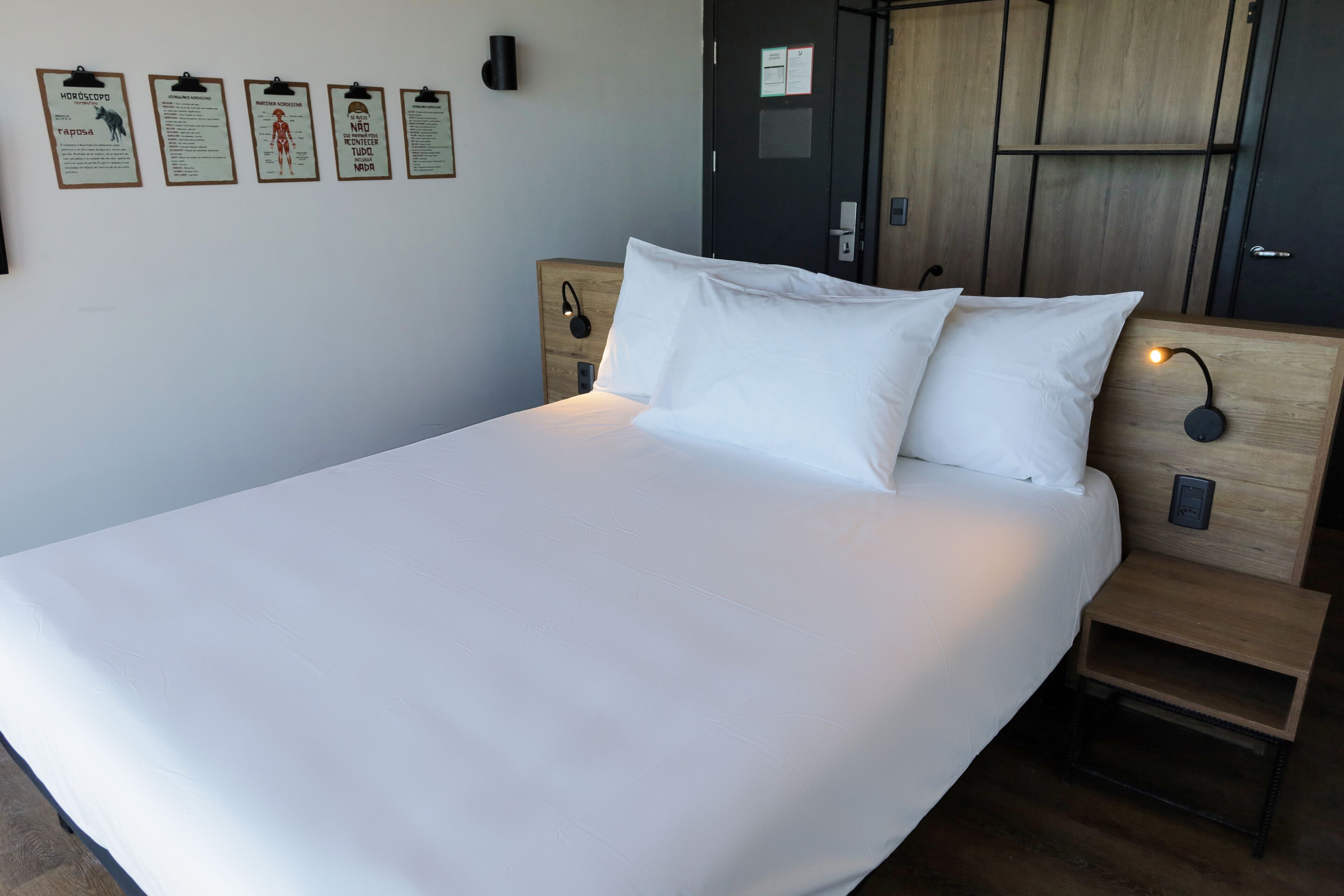 Cama bem arrumada com lençóis brancos em um quarto de hotel.