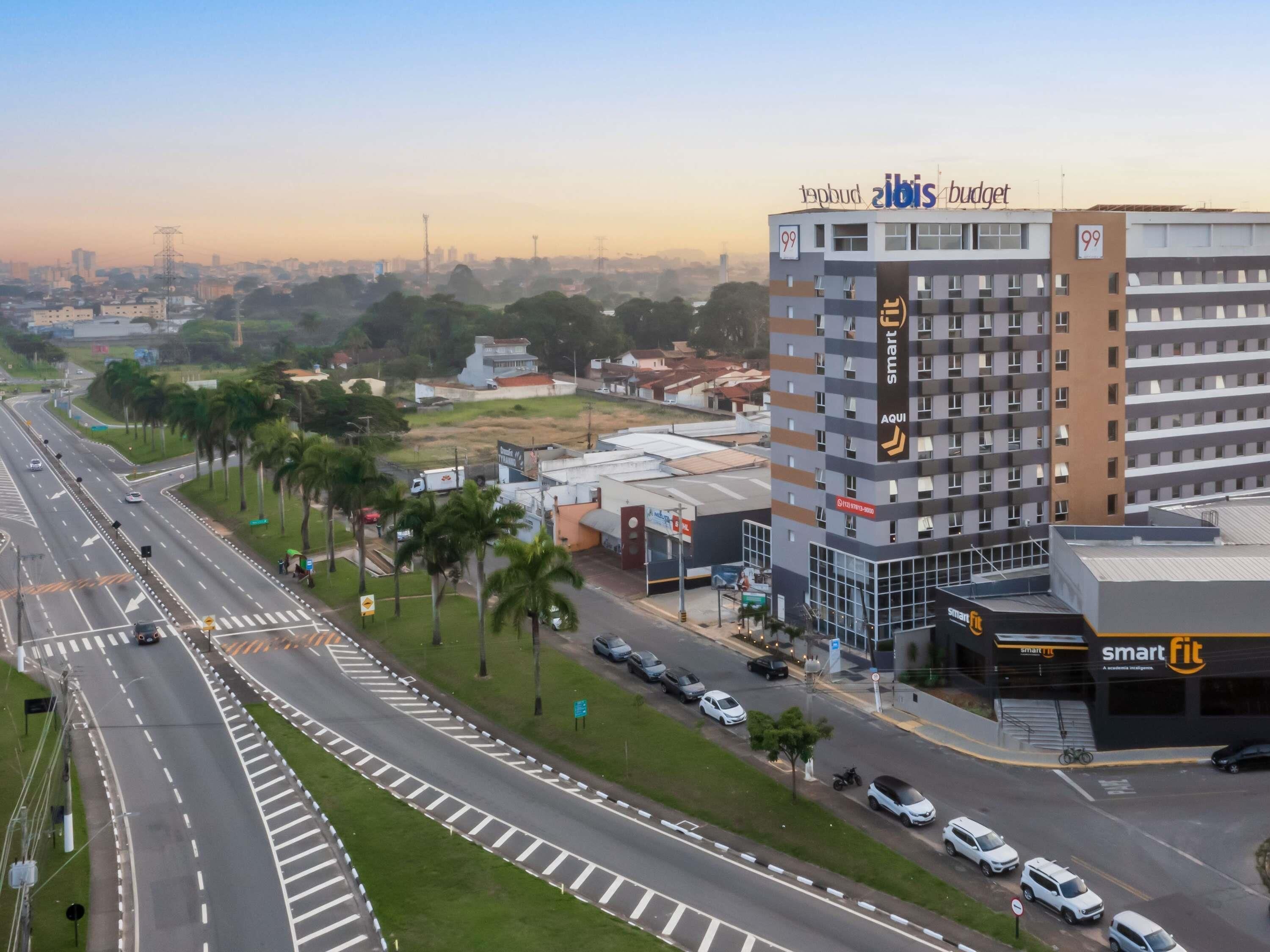 Un edificio de varios pisos con señalización que indica 'Smart Fit' y 'AQUI'.