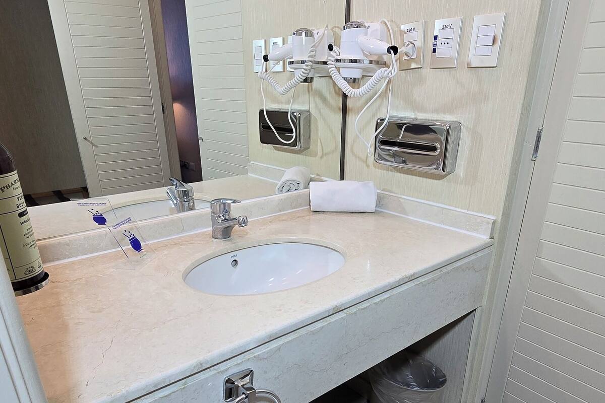 Un baño moderno con lavamanos doble, toallero y espejo.