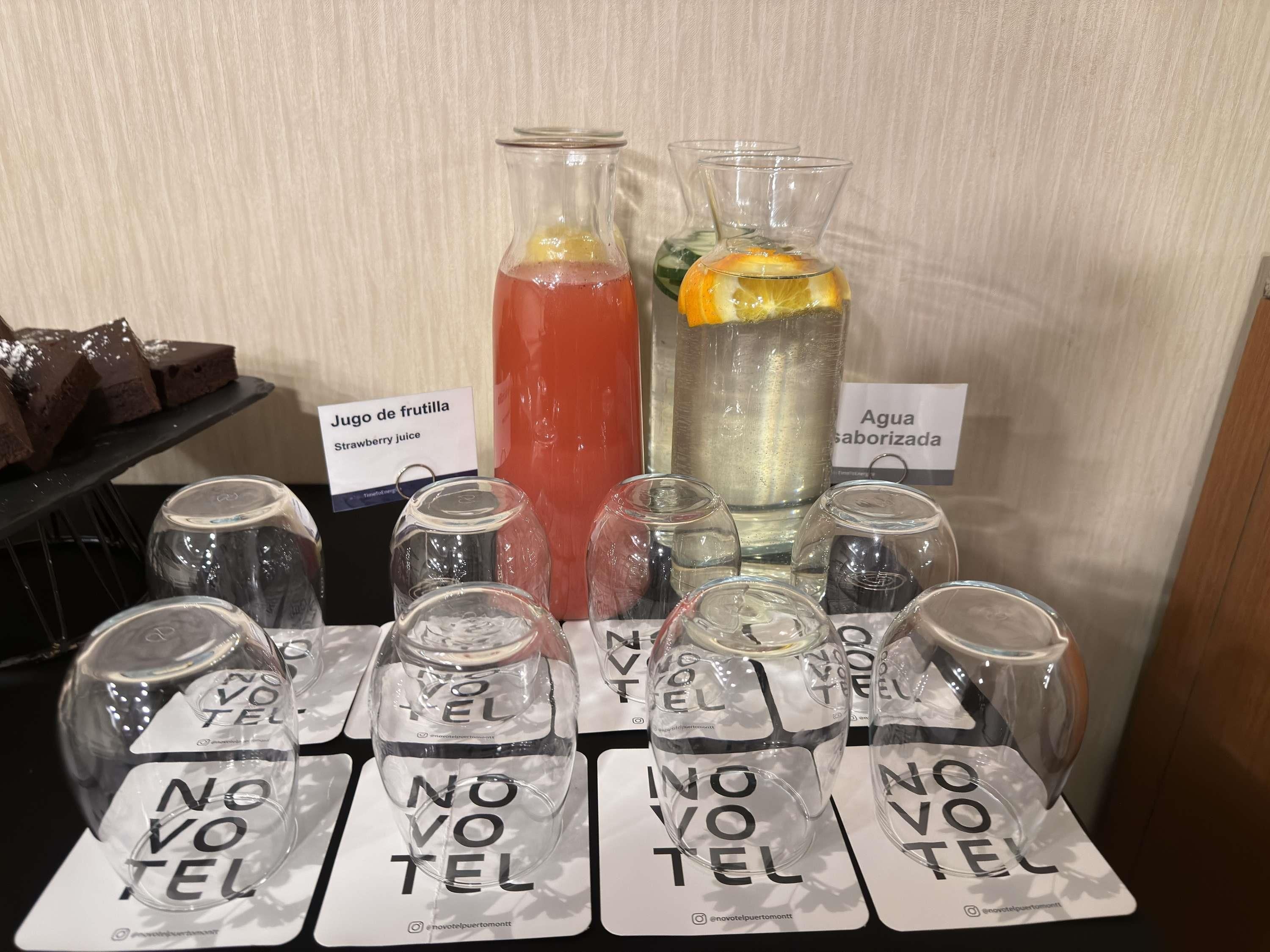 A beverage station with labeled drinks and glasses.