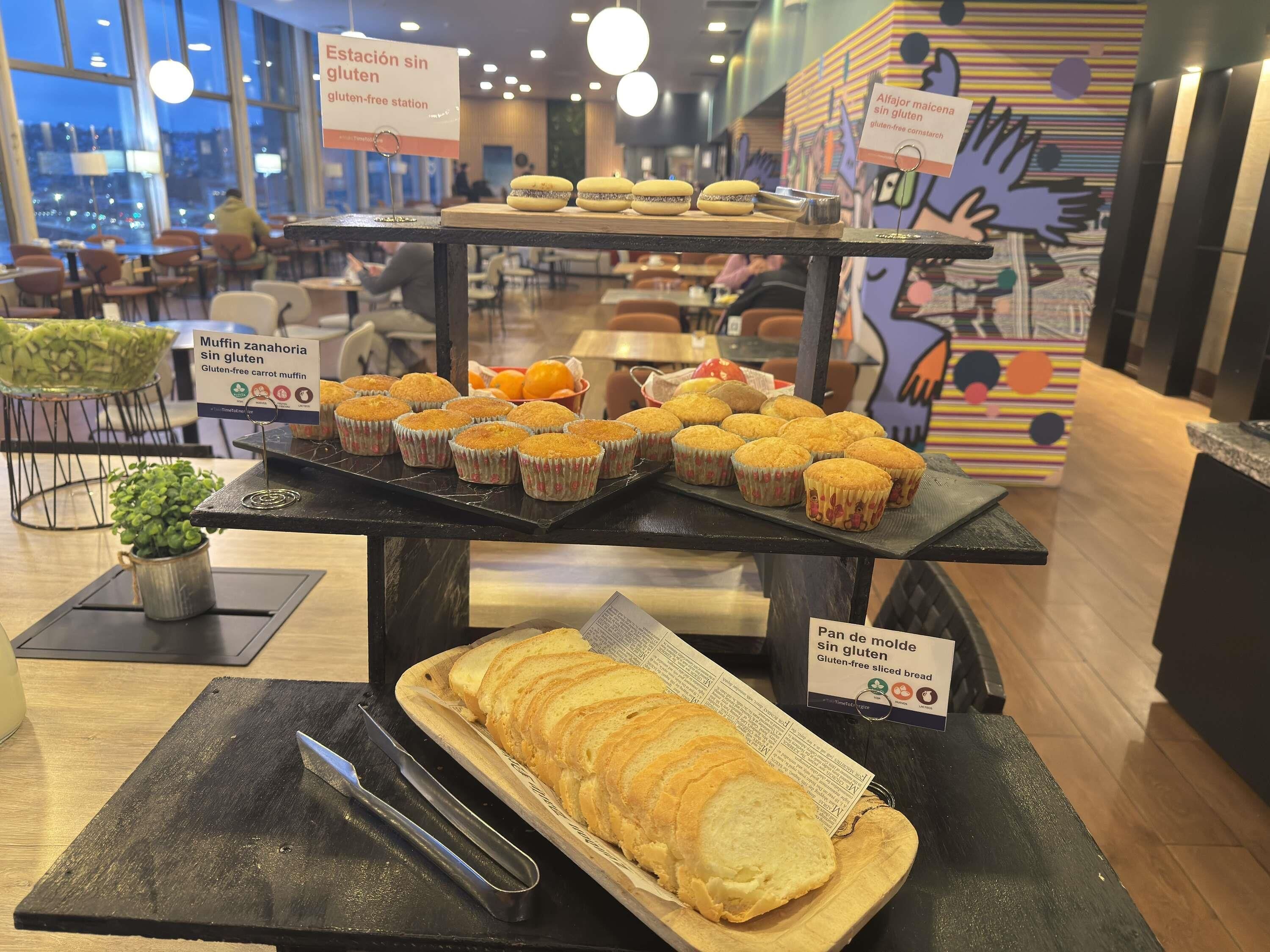 A bakery display with gluten-free options, including muffins and sliced bread.