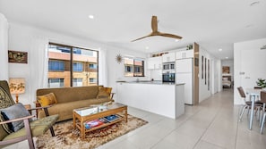 Relax in this spacious living room with a sofa, dining area, and fully equipped kitchen.