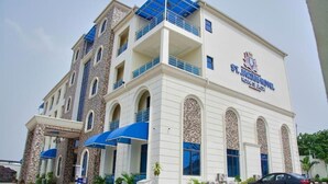 A multi-story hotel with a stone facade, blue awnings, and a sign reading "St. Jacobs Hotel." - St Jacobs Hotel (Akure)
