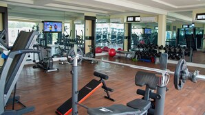 A gym with cardio machines, weightlifting equipment, and mirrors. - St Jacobs Hotel (Akure)
