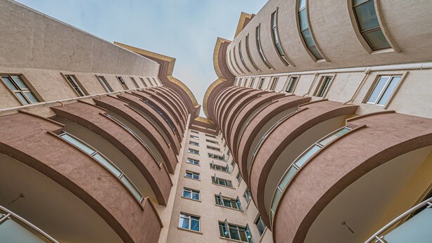 Ein Hochhaus mit markanter Architektur, das durch geschwungene Balkone und zahlreiche Fenster gekennzeichnet ist.