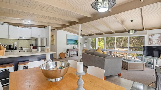 A spacious living area with a kitchen, dining table, and seating area. - Amongst The Ti-Trees - Rye (Rye)