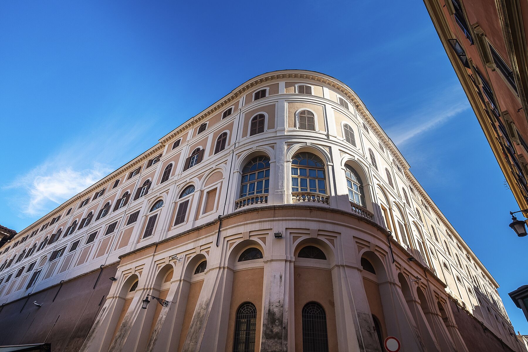 A historic building with classical architecture, featuring arched windows and a curved facade.